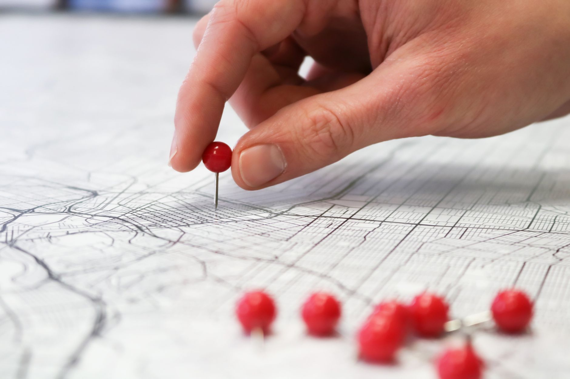 hand placing pin on map